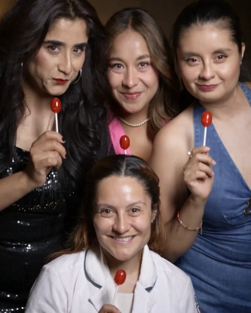 Cuatro actrices de una comedia posan con paletas rojas
