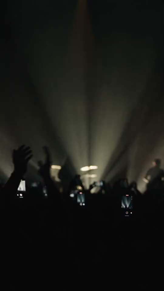 Una banda en el escenario entre luces ámbar; cae confeti sobre el público